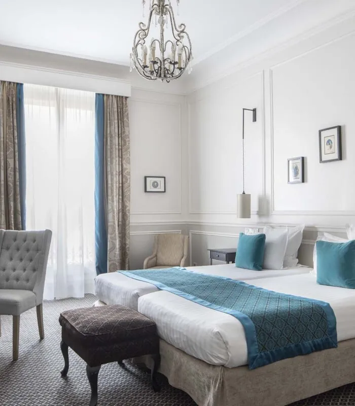 Chambre Familiale Supérieure avec deux lits et un bureau à l’Hôtel Bradford Élysées