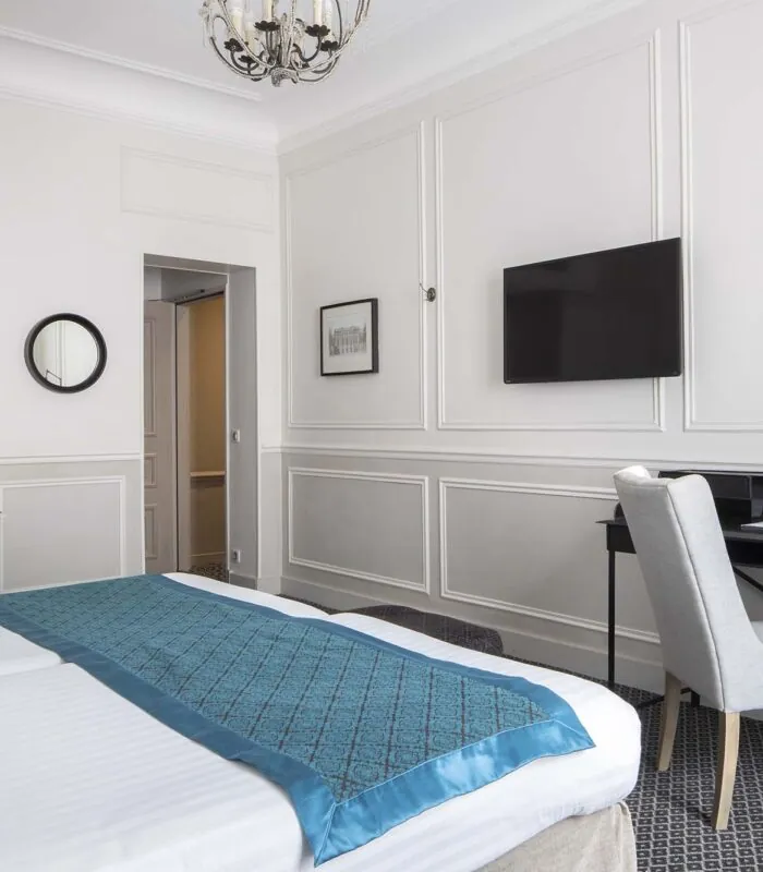 Chambre Familiale Supérieure avec un lit, un bureau et une télévision à écran plat à l’Hôtel Bradford Élysées