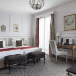 Chambre Privilège Balcon avec deux lits et un bureau à l’Hôtel Bradford Elysées
