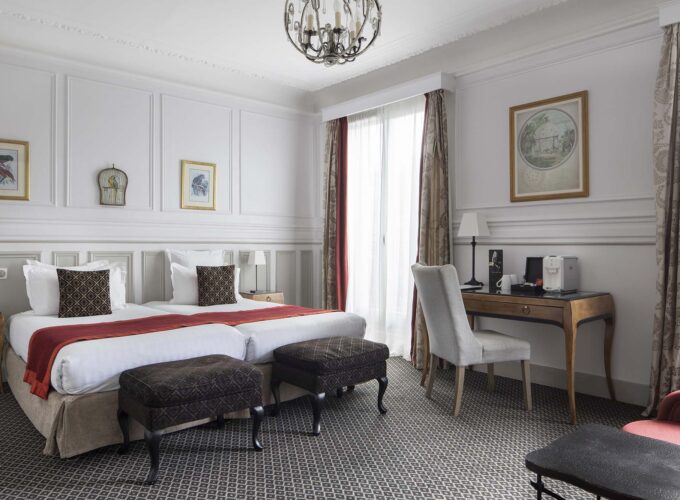 Chambre Privilège Balcon avec deux lits et un bureau à l’Hôtel Bradford Elysées