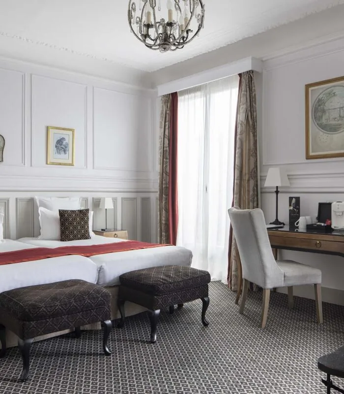 Chambre Privilège Balcon avec deux lits et un bureau à l’Hôtel Bradford Elysées