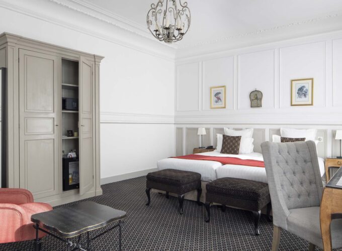 Chambre Privilège Balcon avec deux lits et un bureau à l’Hôtel Bradford Elysées