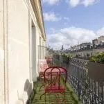 Chambre Privilège Balcon un balcon avec deux chaises rouges et une table à l’Hôtel Bradford Elysées