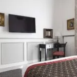Chambre Single avec une grande télévision à écran plat fixée au mur à l’hôtel Bradford Elysées