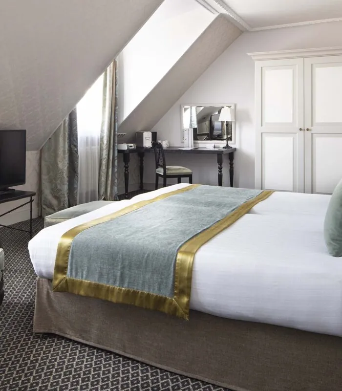Chambre Triple Privilège avec un grand lit et une télévision à écran plat à l’Hôtel Bradford Elysées