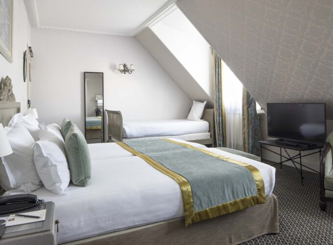 Chambre Triple Privilège avec deux lits et une télévision à écran plat à l’Hôtel Bradford Elysées