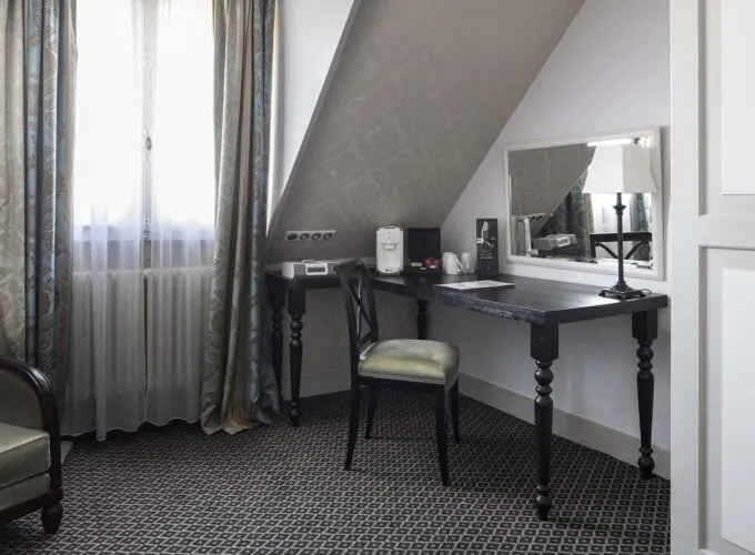 Chambre Triple Privilège avec un bureau une chaise et un miroir à l’Hôtel Bradford Elysées