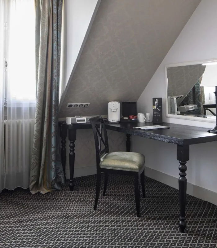 Chambre Triple Privilège avec un bureau une chaise et un miroir à l’Hôtel Bradford Elysées