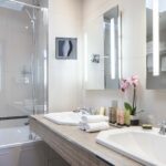 Chambre Triple Privilège salle de bain avec deux lavabos et une baignoire et le lavabo porte l’inscription Duravit à l’Hôtel Bradford Elysées