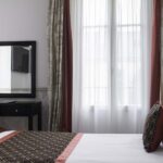 Chambre Twin avec un lit, un bureau et un miroir à l’Hôtel Bradford Élysées