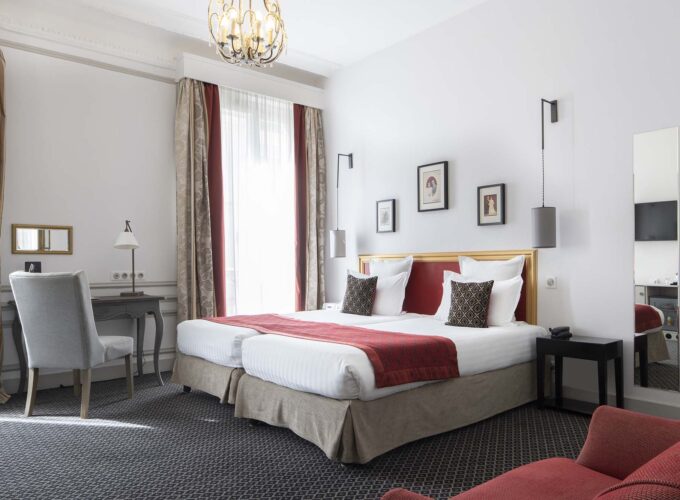Chambre Twin Supérieure avec deux lits et une chaise à l’Hôtel Bradford Élysées