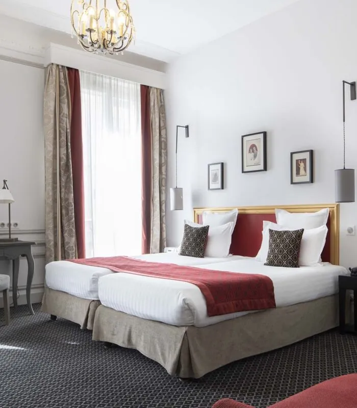 Chambre Twin Supérieure avec deux lits et une chaise à l’Hôtel Bradford Élysées