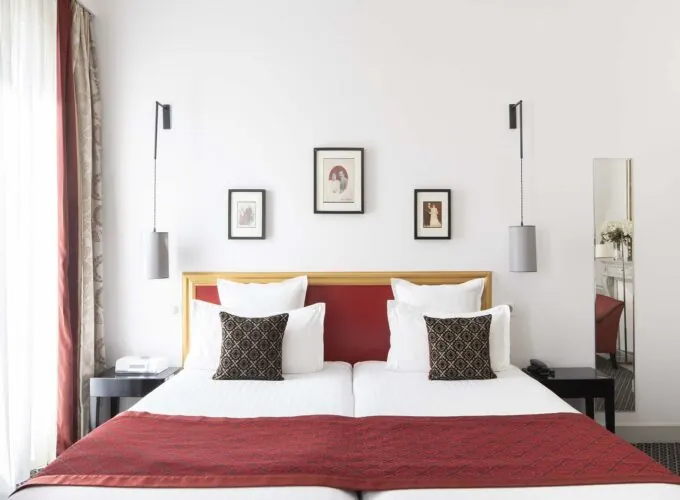Chambre Twin Supérieure avec un lit et trois tableaux au mur à l’Hôtel Bradford Élysées