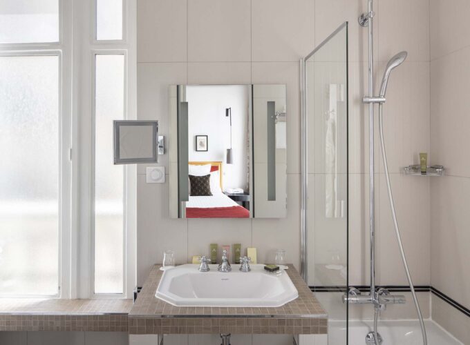 Salle de bain Twin Supérieure avec un lavabo, un miroir et une douche à l’Hôtel Bradford Élysées