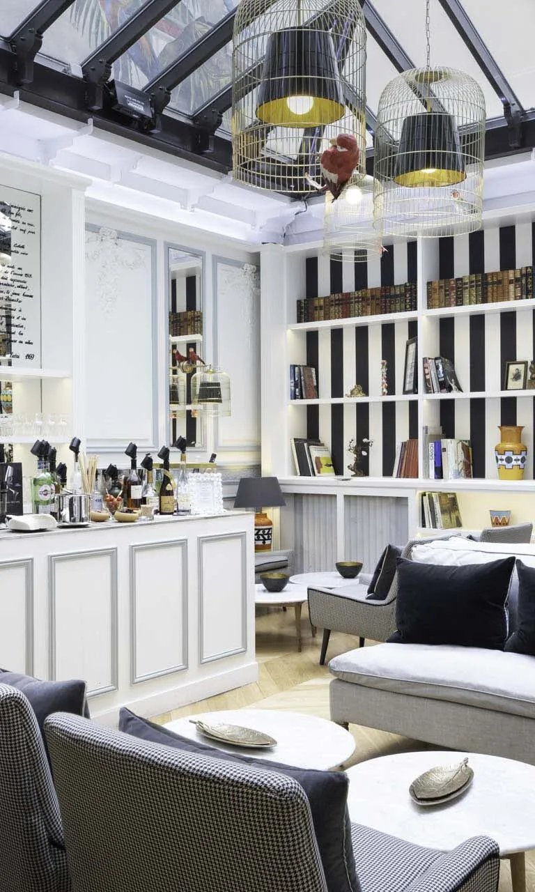 Элегантный бар Отеля Брэдфорд Элизе (Bradford Élysées) в Париже с современными стеллажами, удобными креслами и оригинальными светильниками