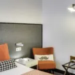 Appartement coin de chambre avec une chaise et un coussin à moustache à l’hôtel George