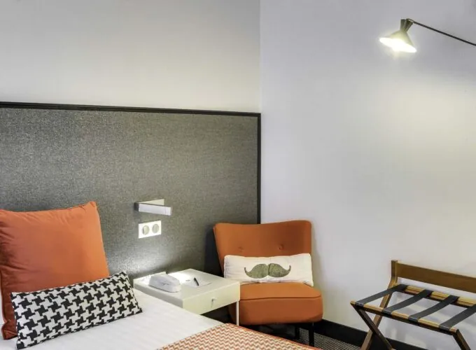 Appartement coin de chambre avec une chaise et un coussin à moustache à l’hôtel George