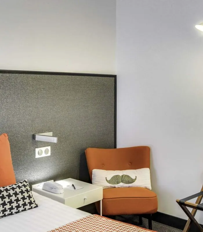 Appartement coin de chambre avec une chaise et un coussin à moustache à l’hôtel George