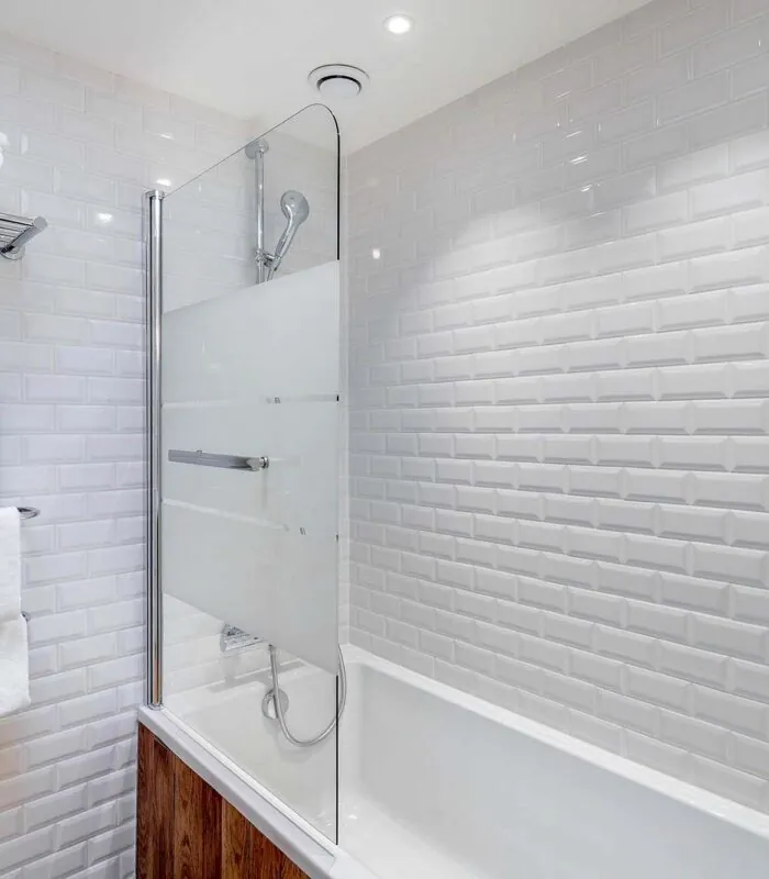 Appartement salle de bain avec des carreaux blancs et une baignoire à l’hôtel George