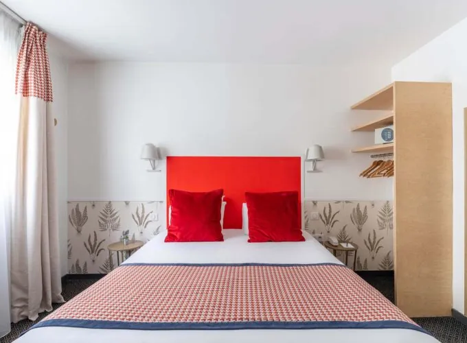 Chambre Communicante avec une tête de lit rouge et des oreillers rouges à l’hôtel George