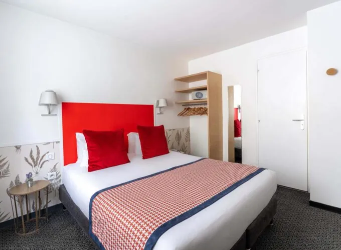 Chambre Communicante avec une tête de lit rouge et des oreillers rouges à l’hôtel George