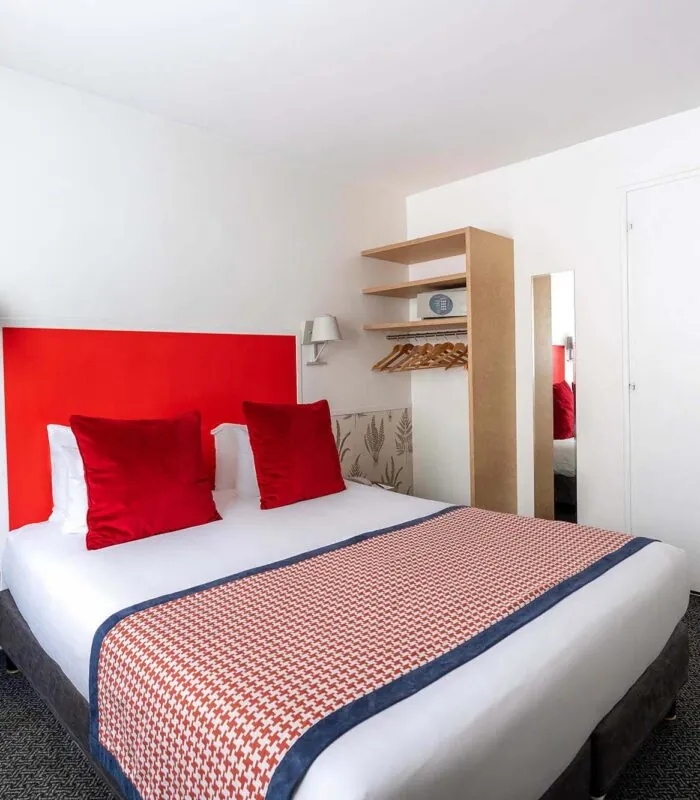 Chambre Communicante avec une tête de lit rouge et des oreillers rouges à l’hôtel George