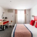 Chambre Communicante avec une tête de lit rouge et des oreillers rouges à l’hôtel George