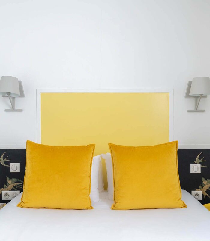 Chambre Communicante avec une tête de lit jaune et des oreillers jaunes à l’hôtel George