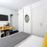 Chambre Communicante avec un lit, un bureau et une télévision à écran plat à l’hôtel George