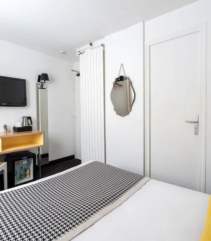 Chambre Communicante avec un lit, un bureau et une télévision à écran plat à l’hôtel George