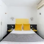Chambre Communicante petite chambre avec une tête de lit jaune et des oreillers jaunes à l’hôtel George