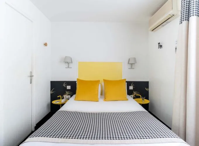 Chambre Communicante petite chambre avec une tête de lit jaune et des oreillers jaunes à l’hôtel George
