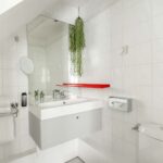 Chambre Communicante salle de bain avec un lavabo, des toilettes et un miroir à l’hôtel George