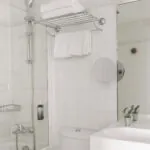 Chambre Communicante salle de bain avec un lavabo, des toilettes et un miroir à l’hôtel George