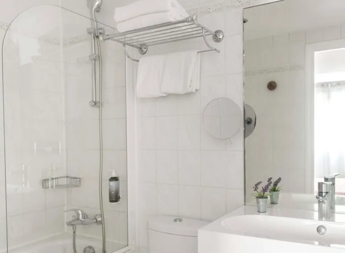 Chambre Communicante salle de bain avec un lavabo, des toilettes et un miroir à l’hôtel George