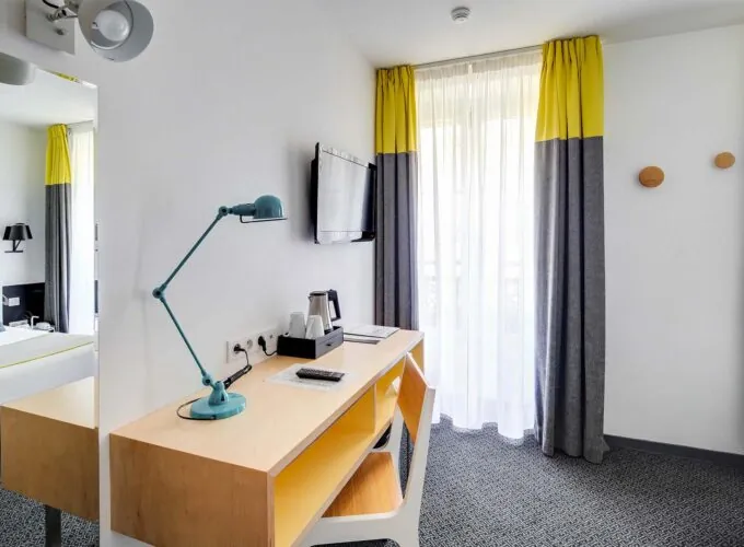 Chambre Double avec un bureau et une télévision au mur à l’Hôtel George