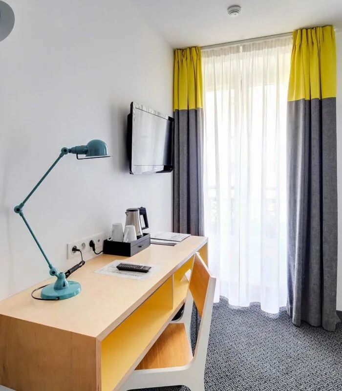 Chambre Double avec un bureau et une télévision au mur à l’Hôtel George