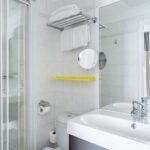 Salle de bain de la Chambre Double avec un lavabo, des toilettes, une douche et un miroir à l’Hôtel George