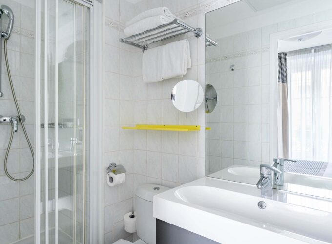 Salle de bain de la Chambre Double avec un lavabo, des toilettes, une douche et un miroir à l’Hôtel George
