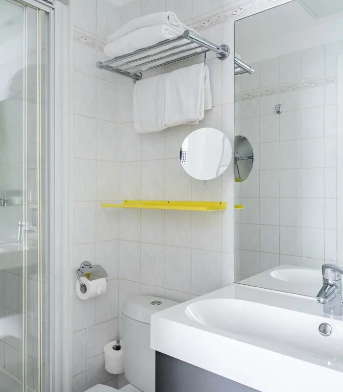 Salle de bain de la Chambre Double avec un lavabo, des toilettes, une douche et un miroir à l’Hôtel George