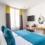 Chambre Familiale avec deux lits et un bureau à l’hôtel George