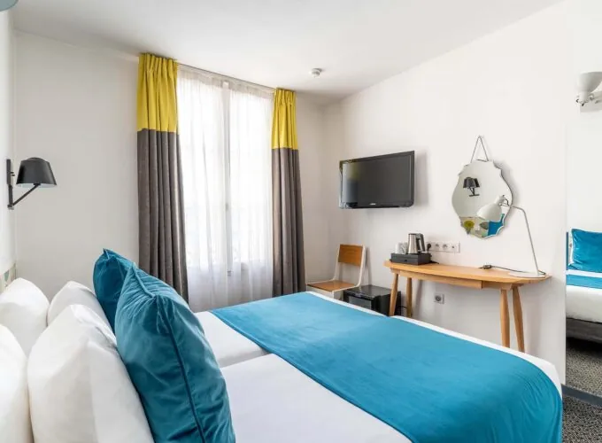 Chambre Familiale avec deux lits et un bureau à l’hôtel George