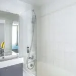 Chambre Familiale salle de bain avec un lavabo, un miroir et une douche à l’hôtel George