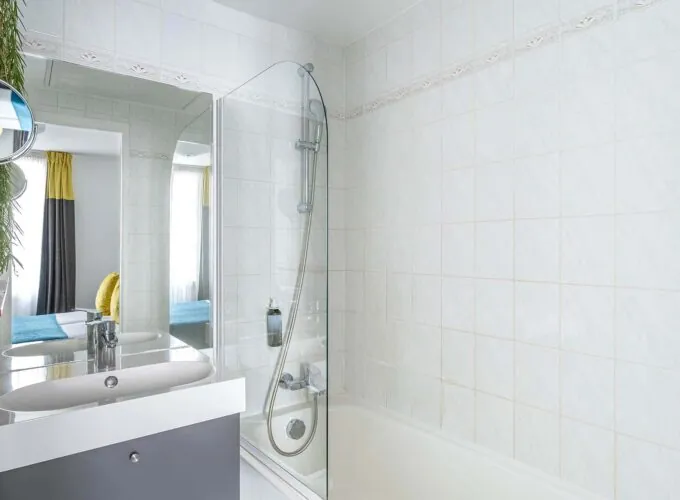 Chambre Familiale salle de bain avec un lavabo, un miroir et une douche à l’hôtel George