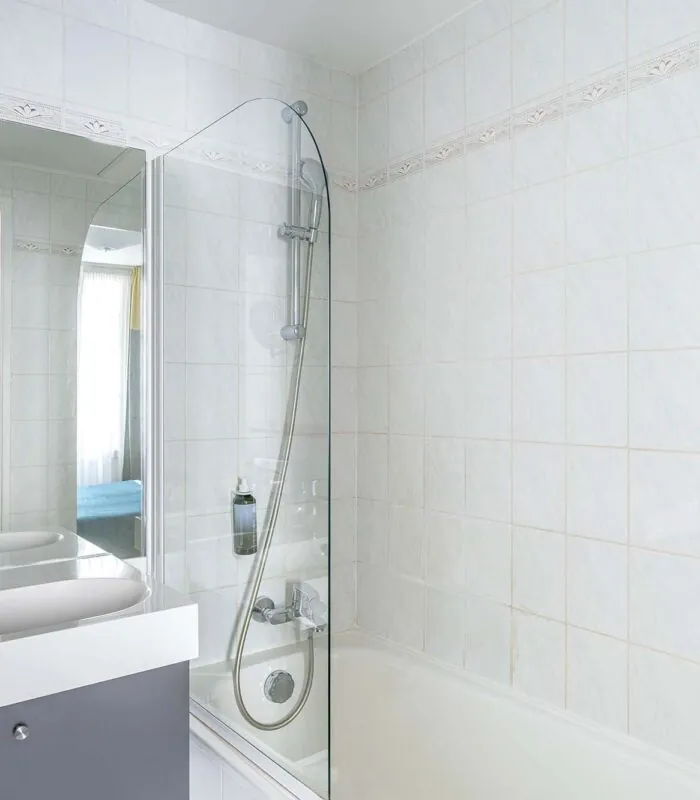 Chambre Familiale salle de bain avec un lavabo, un miroir et une douche à l’hôtel George