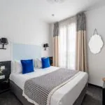 Chambre Single avec un lit et un miroir à l’Hôtel George