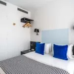 Chambre Single avec un oreiller bleu sur le lit à l’Hôtel George