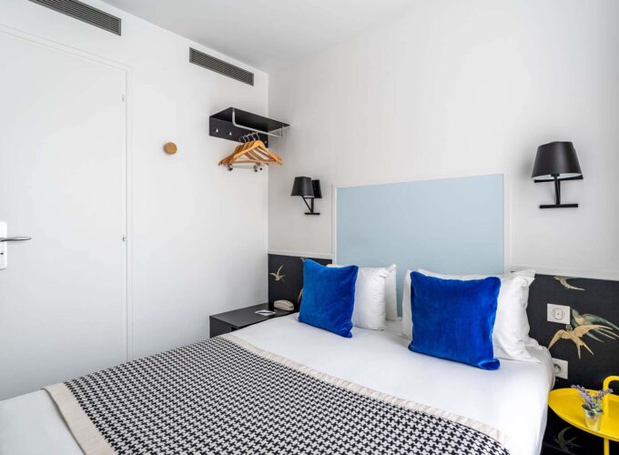 Chambre Single avec un oreiller bleu sur le lit à l’Hôtel George