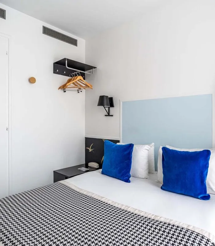 Chambre Single avec un oreiller bleu sur le lit à l’Hôtel George