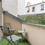 Chambre Triple Terrasse avec petit balcon comprenant deux chaises et une table à l’Hôtel George